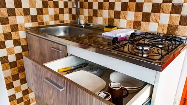 A compact kitchen with a sink, stove, and storage cabinets. - SanAntonio Apartment in Cali, near the best attractions (Cali)
