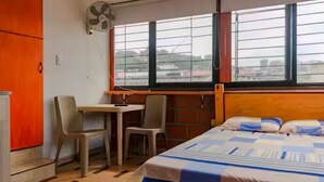 A bedroom with a bed, a desk, a chair, a window, and a fan. - SanAntonio Apartment in Cali, near the best attractions (Cali)