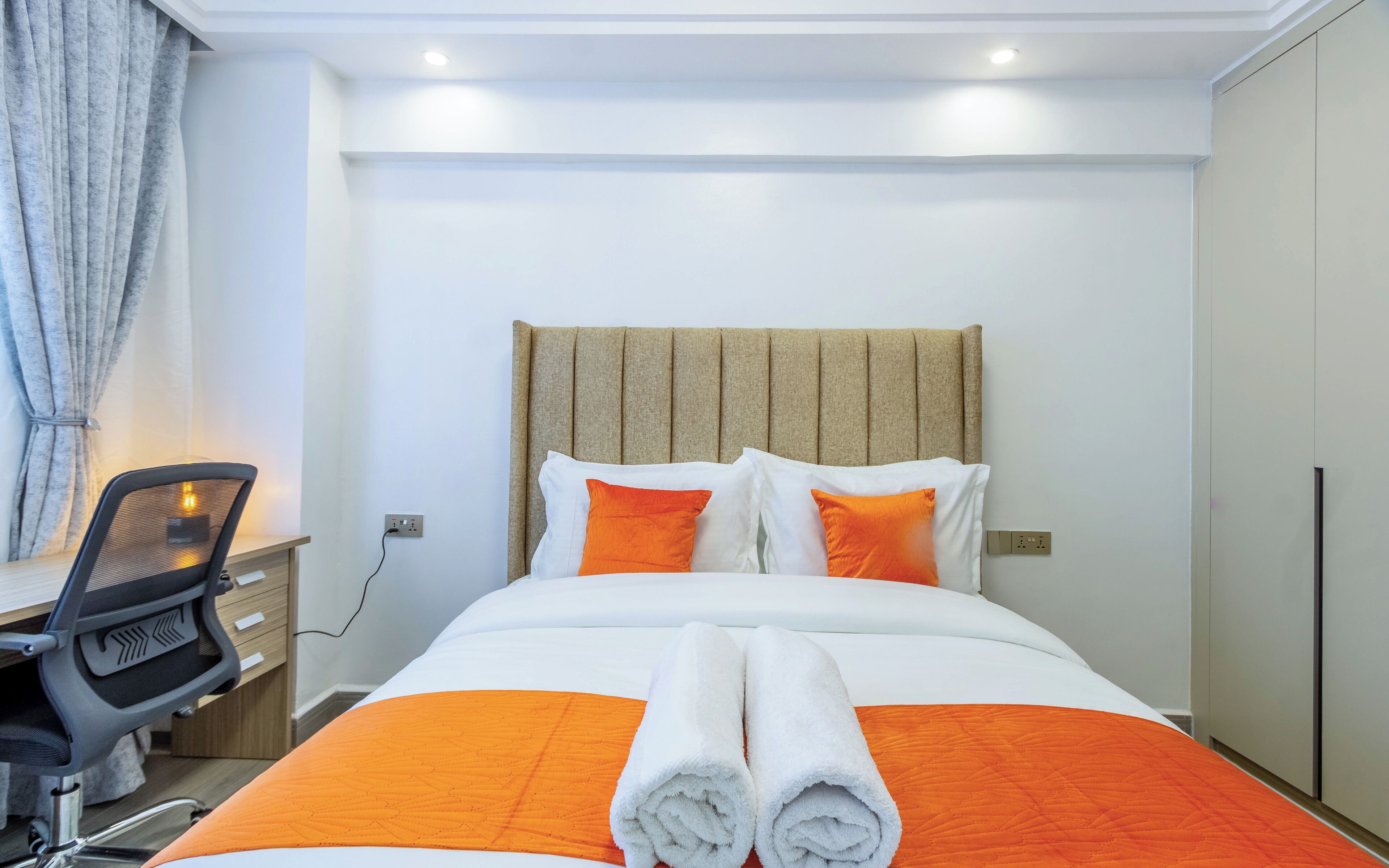 Une chambre d’hôtel avec un lit, un bureau et une chaise.