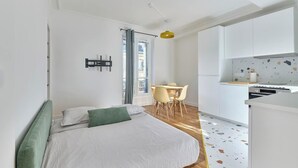 Un dormitorio moderno con una cama, una mesita y un rincón americano.