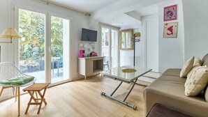 Una habitación amplia con sofá, mesa de comedor y televisor.