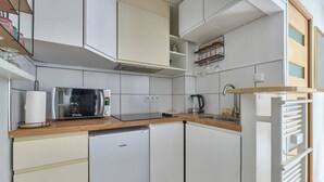 Una cocina compacta equipada con microondas, cafetera y refrigerador pequeño.
