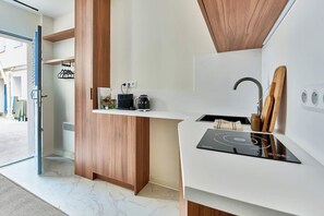 Een moderne keuken met een inbouwfornuis, houten kastjes en een wit aanrecht.