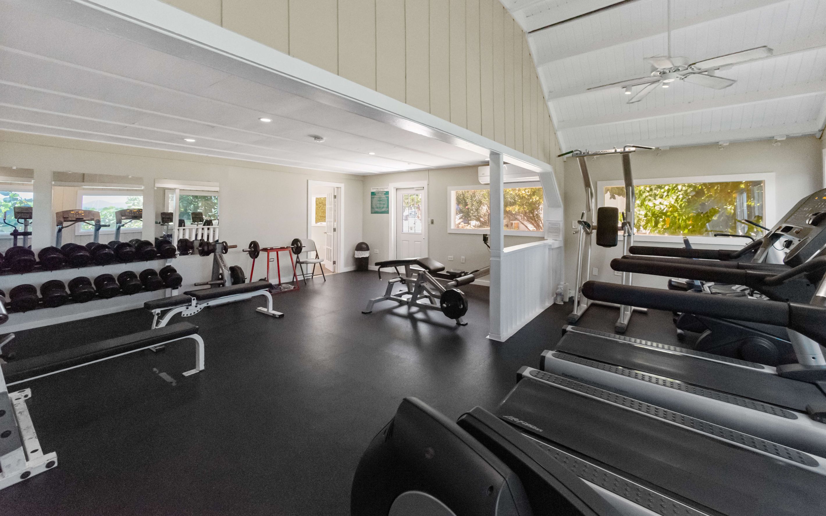 A gym with treadmills, weight machines, and free weights.