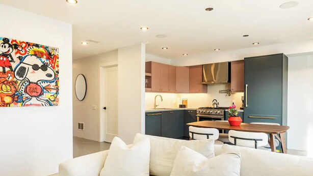 A modern living room with a sofa, a dining table, and a kitchen with cabinets and appliances. - Modern Toronto Residence by the Lake - 2BDR (Toronto)
