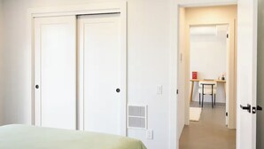 Ein Schlafzimmer mit Bett, Schreibtisch und Stuhl in einer Diele.