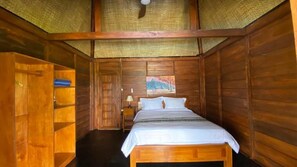A wooden room with a bed, a nightstand, and a shelf. - Katah Montana Villa (Jawa Tengah)