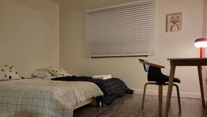 Une chambre avec deux lits, un bureau et une chaise.