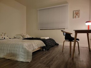 Ein Schlafzimmer mit zwei Betten, einem Schreibtisch und einem Stuhl.