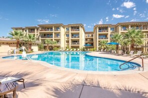 A hotel with a swimming pool, palm trees, and a clear blue sky. - BLOCK WM Estancia 3br Penthouse (St. George)