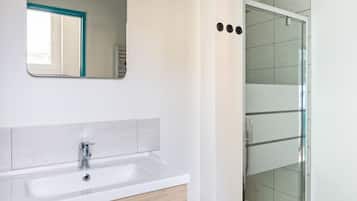Chuveiro, secador de cabelo, toalhas de banho, papel higiênico