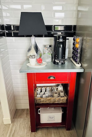 Eine Küche mit Kaffeemaschine, Lampe und Obstkorb.