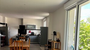A modern kitchen with a dining area, a large window, and a view of the outdoors.