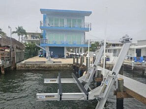 A dock with a blue building in the background, a waterway, and a lifeguard tower. - Lovely 2-bedroom house with AC in enjoyable Key Largo (Key Largo)