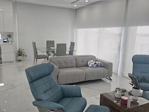 A modern living room with a sofa, chairs, a coffee table, and a dining area. - Lovely 2-bedroom house with AC in enjoyable Key Largo (Key Largo)