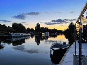 A calm river with boats docked, a dock, and a clear sky. - Island Cottage Rod Eyot (Henley-on-Thames)
