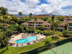 A resort with a swimming pool, multiple buildings, and a mountainous backdrop. - Walk to Poipu Beach, Grand Hyatt & Brennecke's/Poipu Kai Charming Condo (Koloa)