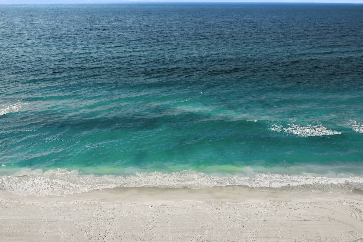 A beach with clear turquoise water and a sandy shore.