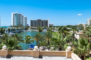 A waterfront hotel with a marina, palm trees, and high-rise buildings in the background. - Siesta Swim House | Indoor Pool | 10 min to Beach (Sarasota)