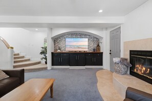 Ein modernes Interieur mit einer Steinwand, einem Kamin und Blick auf das Meer.