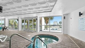 Un espace piscine offrant une vue dégagée sur l’extérieur, un plafond doté d’un éclairage encastré et un panneau d’avertissement fixé au mur.