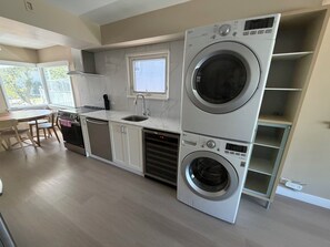 A compact kitchen with built-in appliances, a dining area, and a window. - Newly renovated house in the heart of Vancouver! (Vancouver)