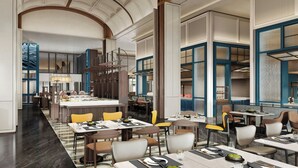 Un restaurante espacioso con techos altos, muebles modernos y una isla central.