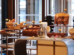 A bakery display with various baked goods and a stand mixer. - Le Méridien Yichang Sanxia (Yichang)