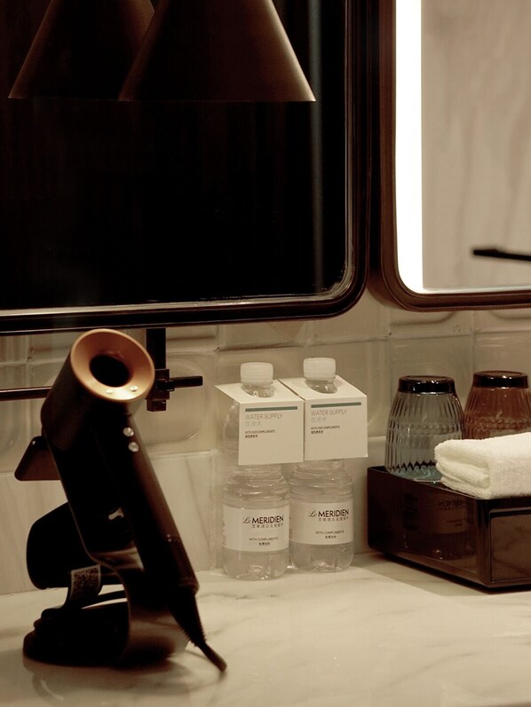 A bathroom with a mirror, a towel rack, and water supply bottles. - Le Méridien Yichang Sanxia (Yichang)
