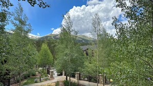 A residential area with a paved driveway, stone pathway, and a view of a mountain. - Grand Timber Lodge 3BR Resort Condo (Breckenridge)