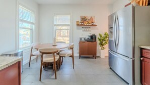 A modern kitchen with a dining table, chairs, a refrigerator, and a microwave. - NEW-Spacious 3BR-Office-Game Room-Laundry In Unit (Everett)
