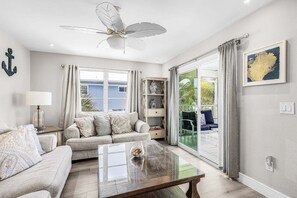 Ein Wohnzimmer mit einer Couch, einem Couchtisch und einem Deckenventilator.