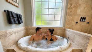 A couple in a jacuzzi with a window above and a tiled wall. - Lake Norman, Pool, Golf Simulator, Sauna, Hot tub, Pickleball/Basketball, EV Chg (Mooresville)