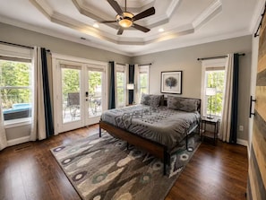 A bedroom with a bed, a ceiling fan, a rug, and a view through the door. - Lake Norman, Pool, Golf Simulator, Sauna, Hot tub, Pickleball/Basketball, EV Chg (Mooresville)