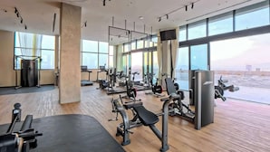 A modern gym with various exercise equipment, large windows, and a view of the sky. - Margot 715 | Diseño, Confort y Ubicación Ideal (Guadalajara)