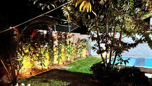 A well-maintained garden with a swimming pool, surrounded by a stone wall and various plants. - Beach house in Alemão offering comfort near the sea. House with pool, near the sea. (Caponga)