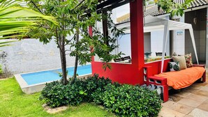 A pool, a red structure, and a bed with pillows. - Beach house in Alemão offering comfort near the sea. House with pool, near the sea. (Caponga)