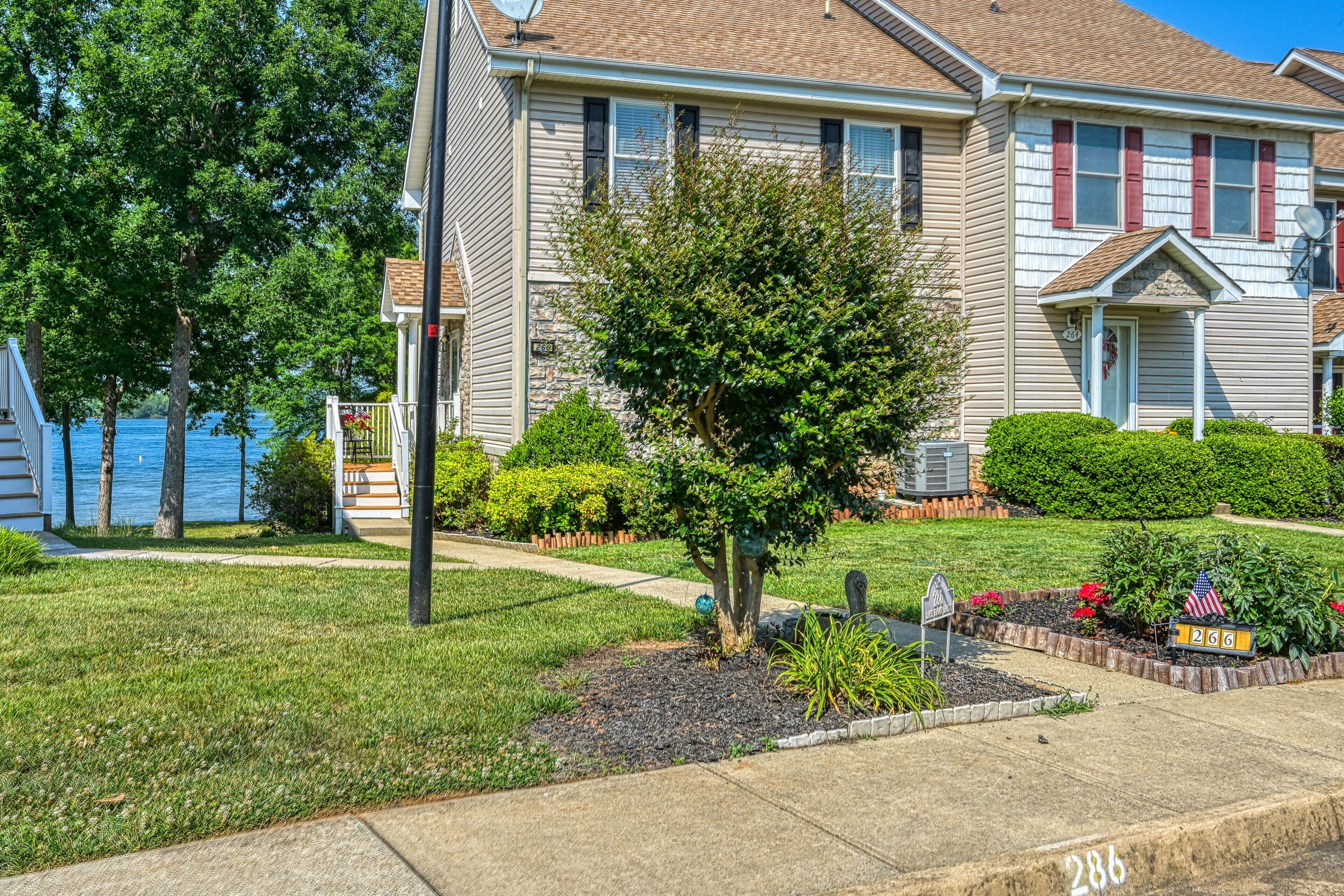 A residential house with a well-maintained lawn, a small tree, and a mailbox.