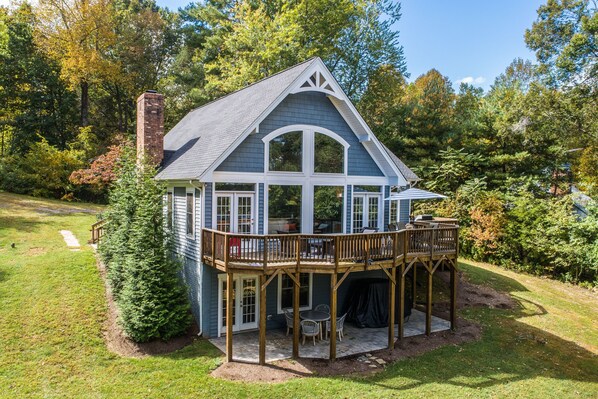 A house with a deck, a chimney, and a garden. - Beautiful Lakefront Home With Fireplace, Deck, Central AC, & Washer/dryer (Mineral)