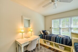 A bedroom with a desk, two lamps, a bed with striped bedding, a ceiling fan, and a window with blinds. - Beautiful Lakefront Home With Fireplace, Deck, Central AC, & Washer/dryer (Mineral)