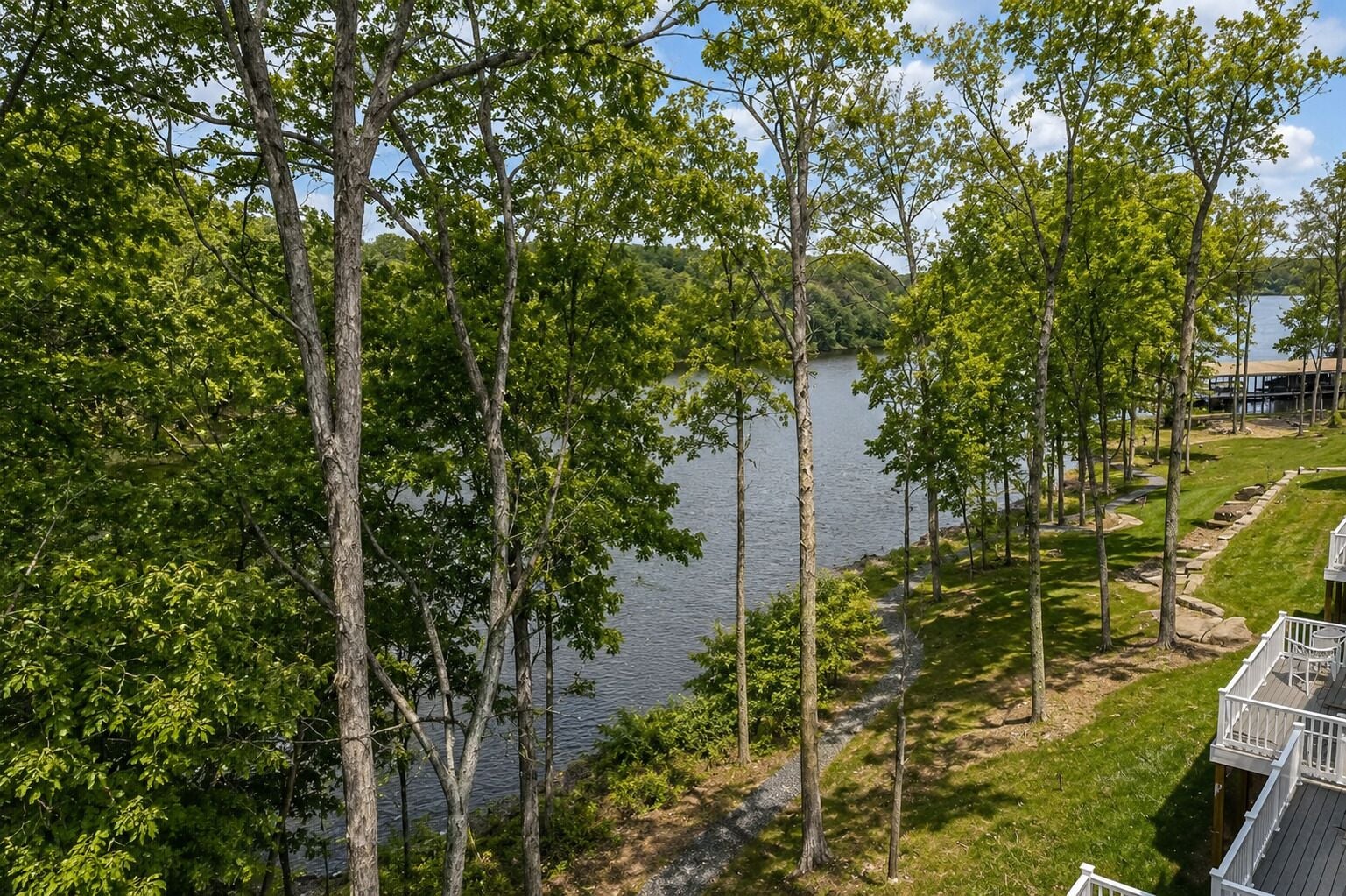 A lakeside property with a deck and a view of the water.