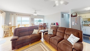 A living room with two brown sofas, a dining table, chairs, a ceiling fan, and a view of the outdoors. - Charming Getaway With a Fireplace, Large Deck, Paddle Boards & Porch Swing (Mineral)