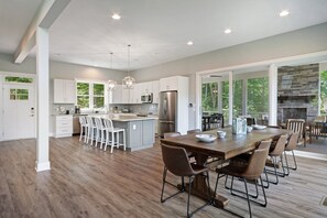A spacious kitchen with a large island, white cabinetry, and modern appliances. - Custom Lakefront Home With Private Beach, Dock & Firepitq (Bumpass)