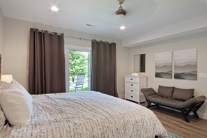 Un dormitorio con cama, una silla, cómoda y vistas a un balcón.