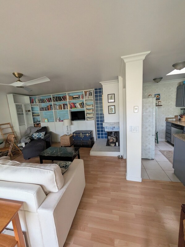Ein Wohnzimmer mit Sofa, Couchtisch, Bücherregal und Fernseher.