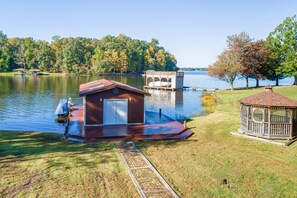 A lakeside property with a dock, a small shed, and a gazebo. - Charming, Lakefront A-frame With Private Dock, Lakeside Gazebo, Spacious Deck (Bumpass)