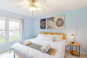 A bedroom with a bed, a ceiling fan, artwork, and a nightstand. - Dog-friendly Lake Luxury With dry Sauna, hot Tub, Game Room (Bumpass)