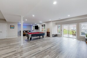 A spacious room with a pool table, a sofa, and a television. - Dog-friendly Lake Luxury With dry Sauna, hot Tub, Game Room (Bumpass)