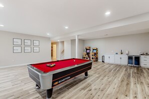 A pool table with a red felt top, a white cabinet with drawers, and framed pictures on the wall. - Dog-friendly Lake Luxury With dry Sauna, hot Tub, Game Room (Bumpass)