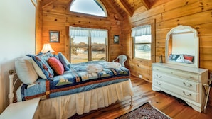 A wooden cabin bedroom with a bed, dresser, and windows. - Dog-friendly, Lake View Cabin w/ Furnished Decks, Ping-pong & Darts (Louisa)